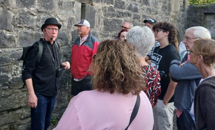 A LetzGo guide in Dublin talking with the group beside a stone wall